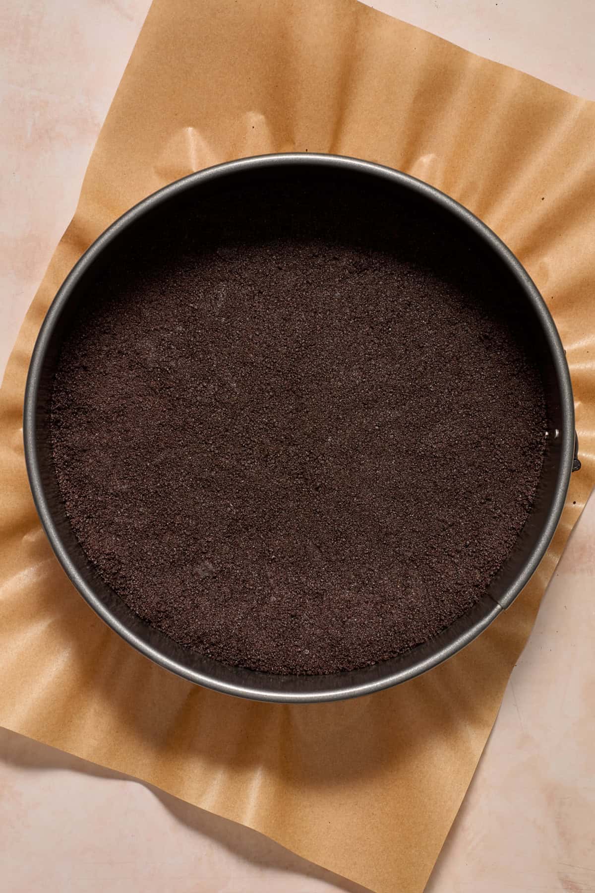 Springform pan with Oreo cookie crust pressed into it.