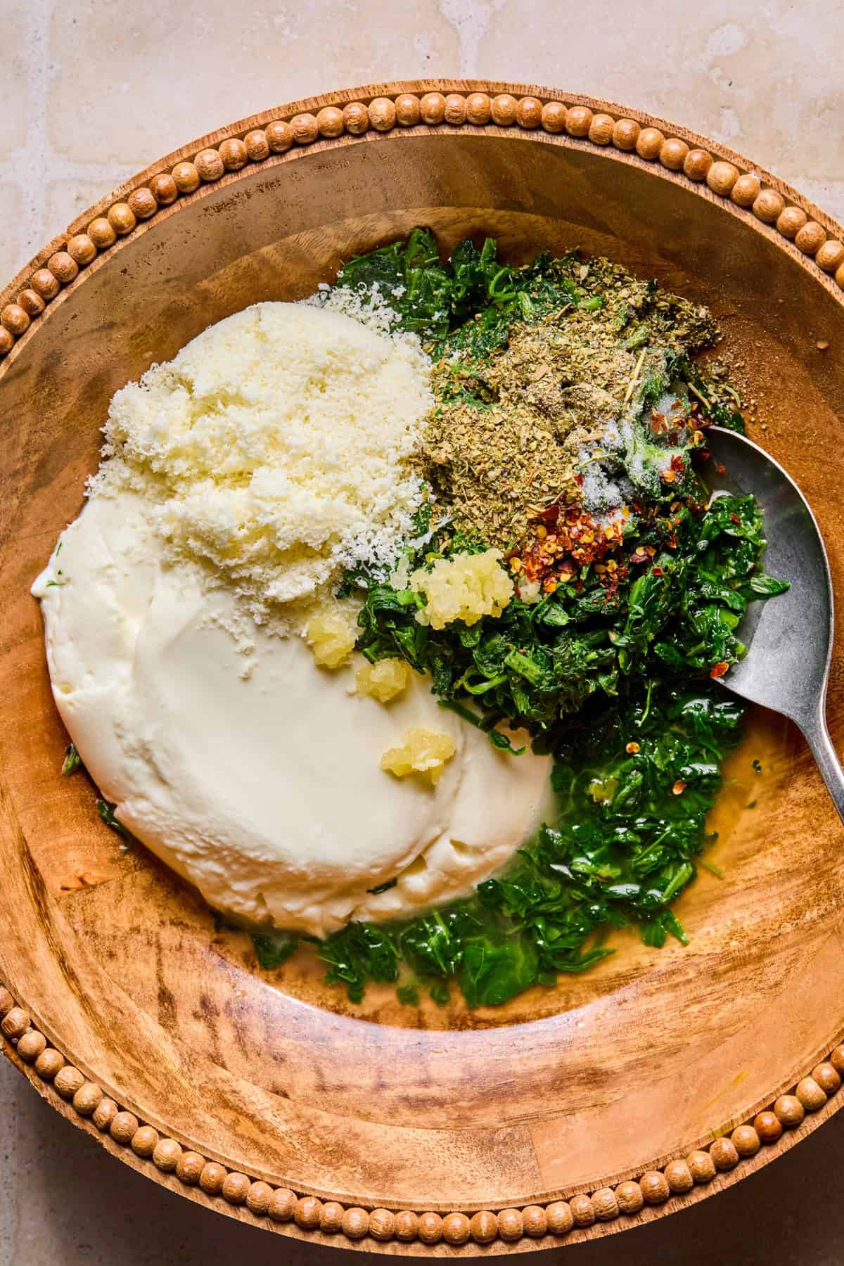 Thawed spinach, parmesan cheese, broth, etc. in bowl before stirring.