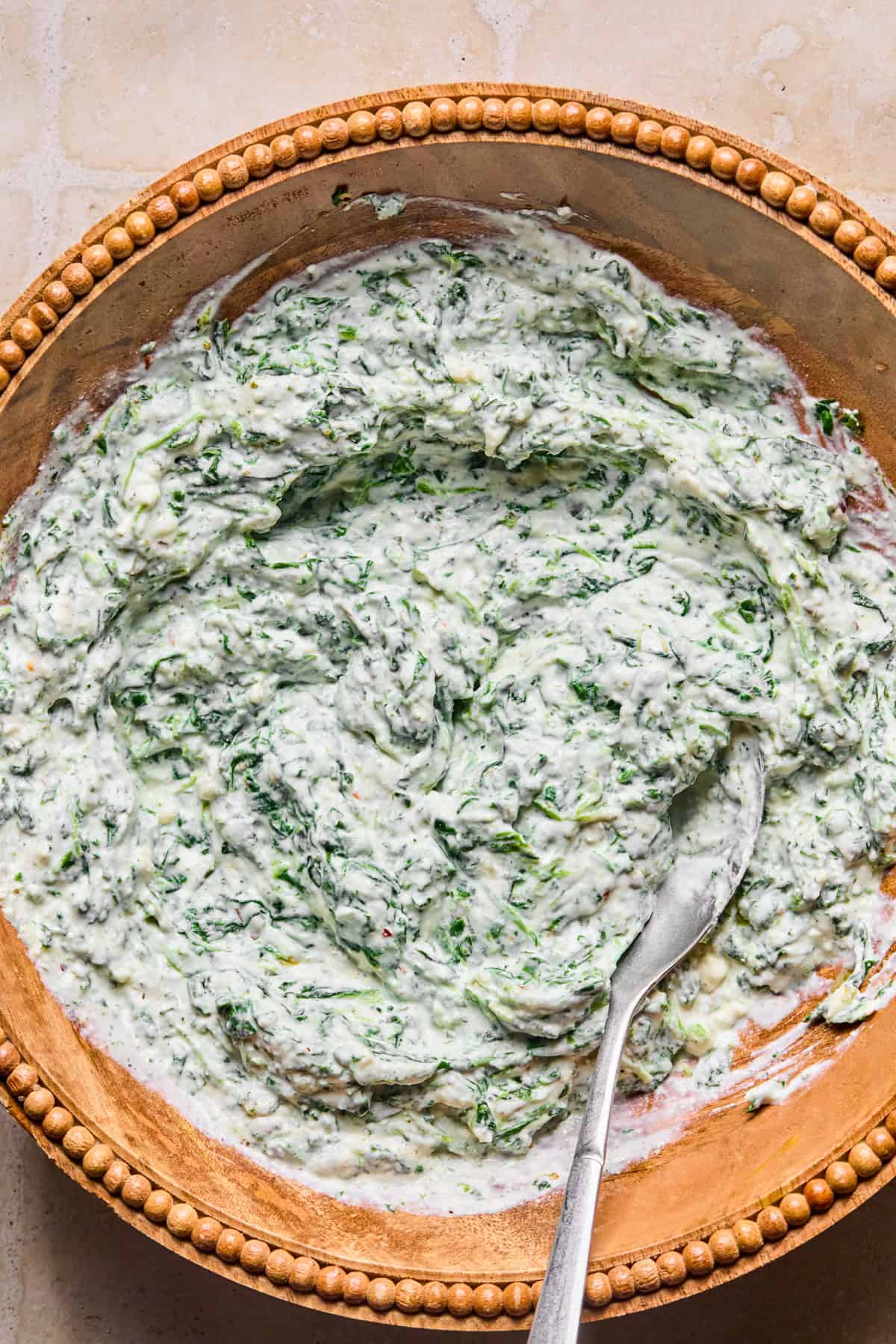 Spinach and ricotta mixture in bowl with spoon.