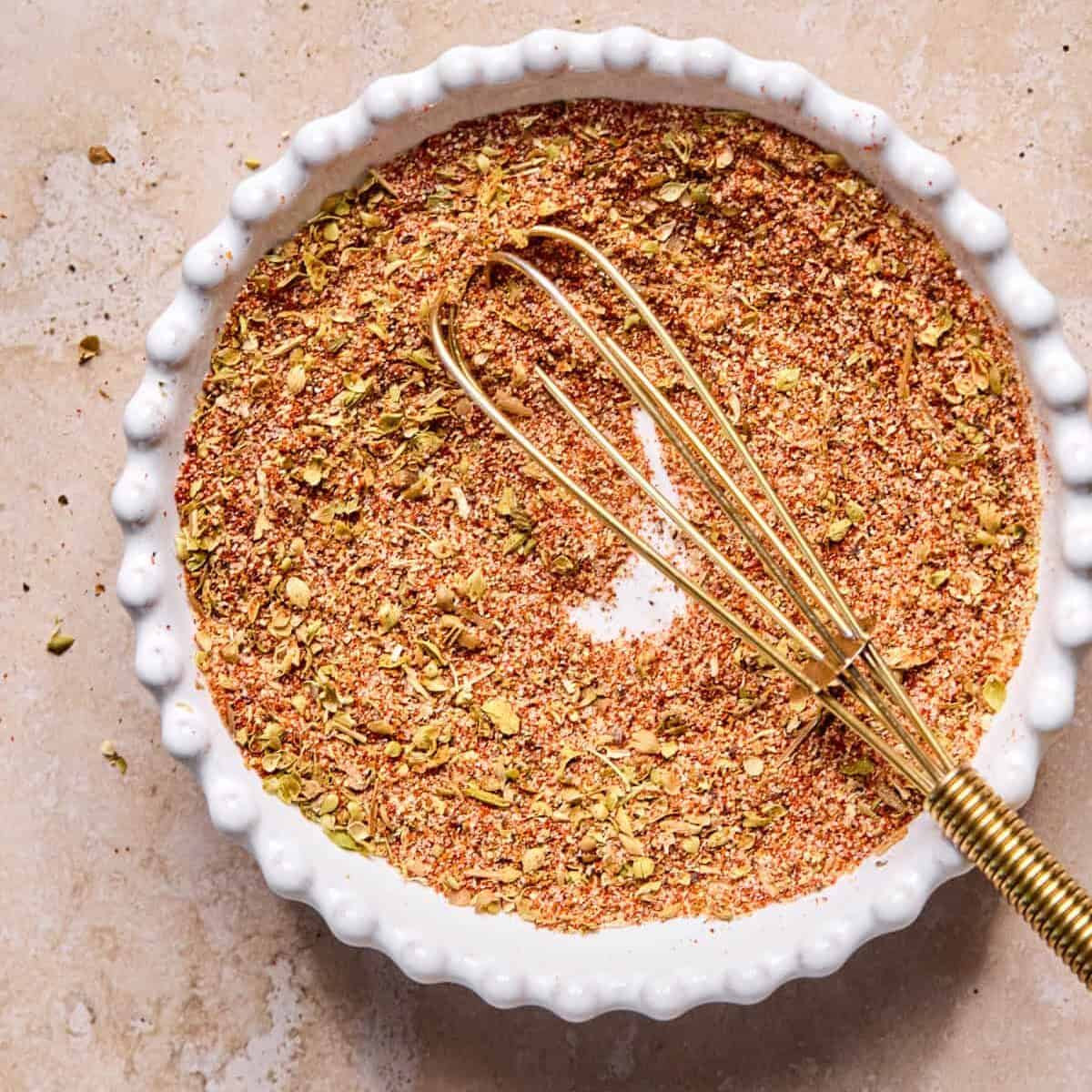 Burger seasoning in bowl with whisk.