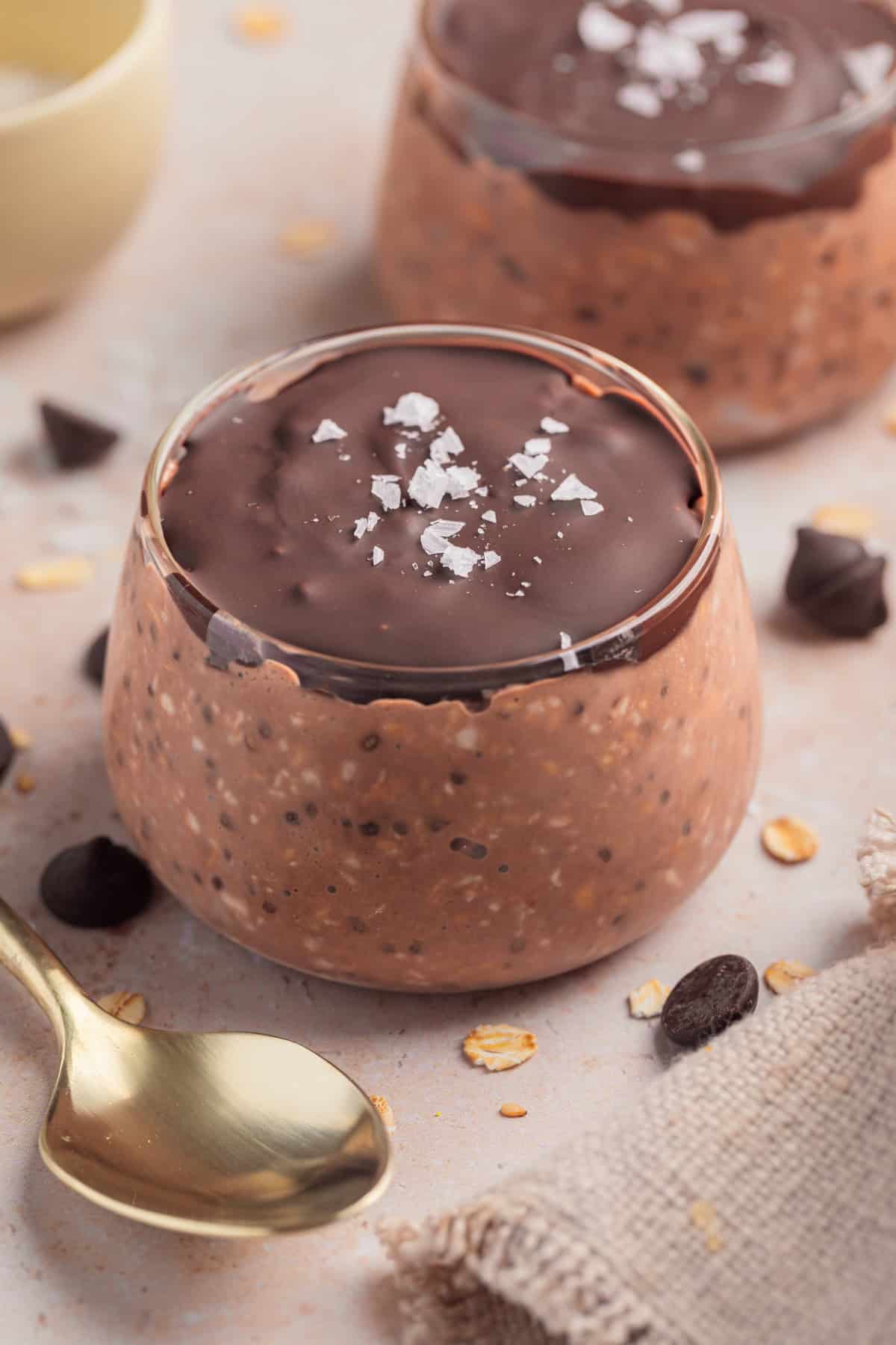 Chocolate oatmeal in dish topped with chocolate and sea salt.
