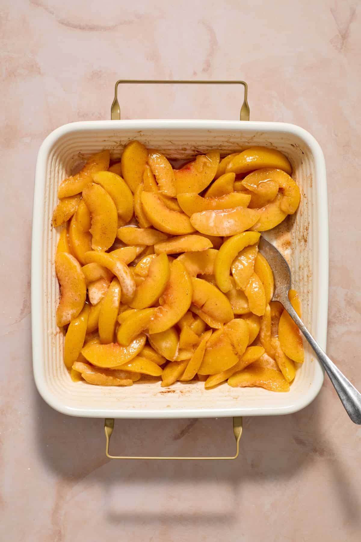Sweetened peaches in 8 inch square baking pan.