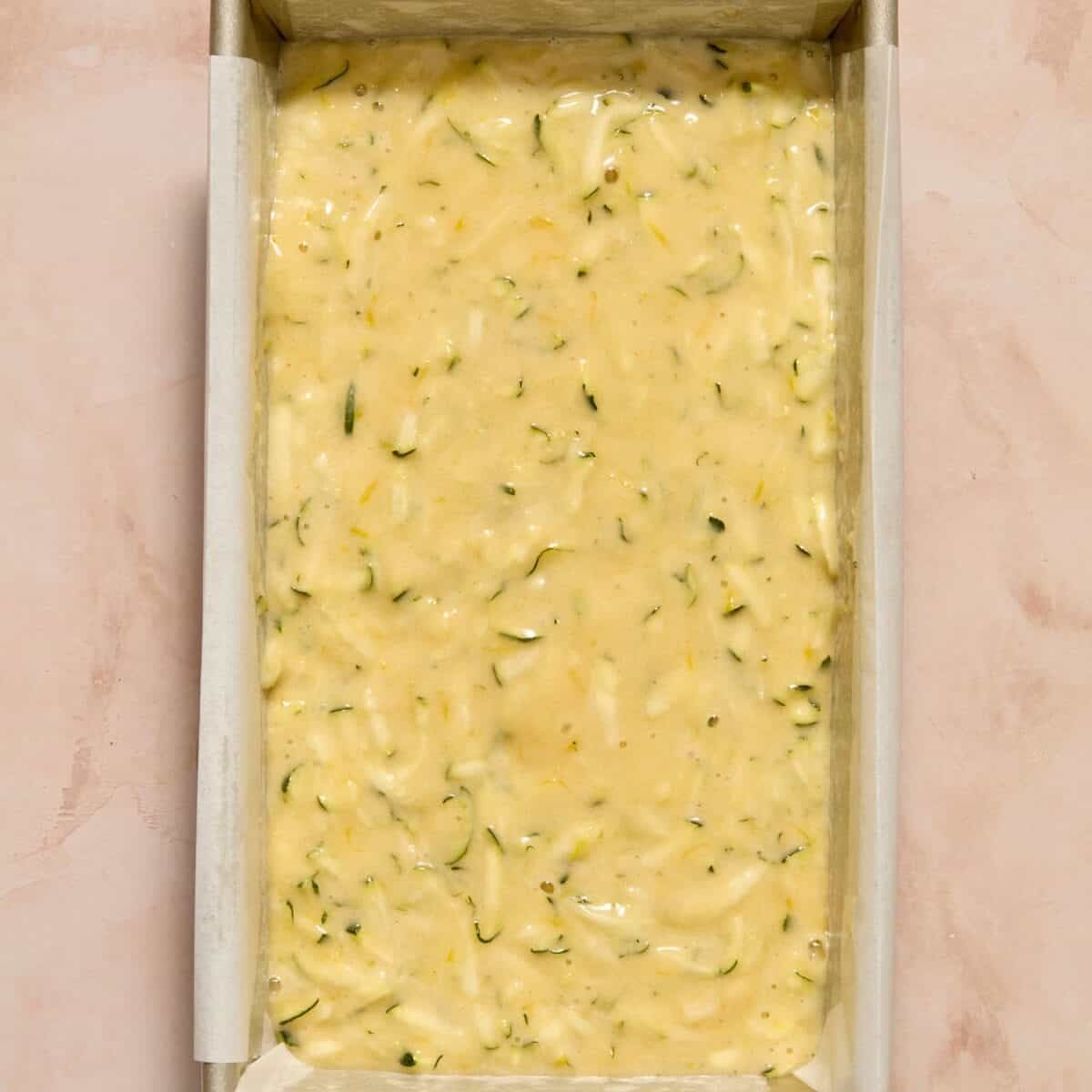 Lemon zucchini bread batter in parchment lined bread pan.