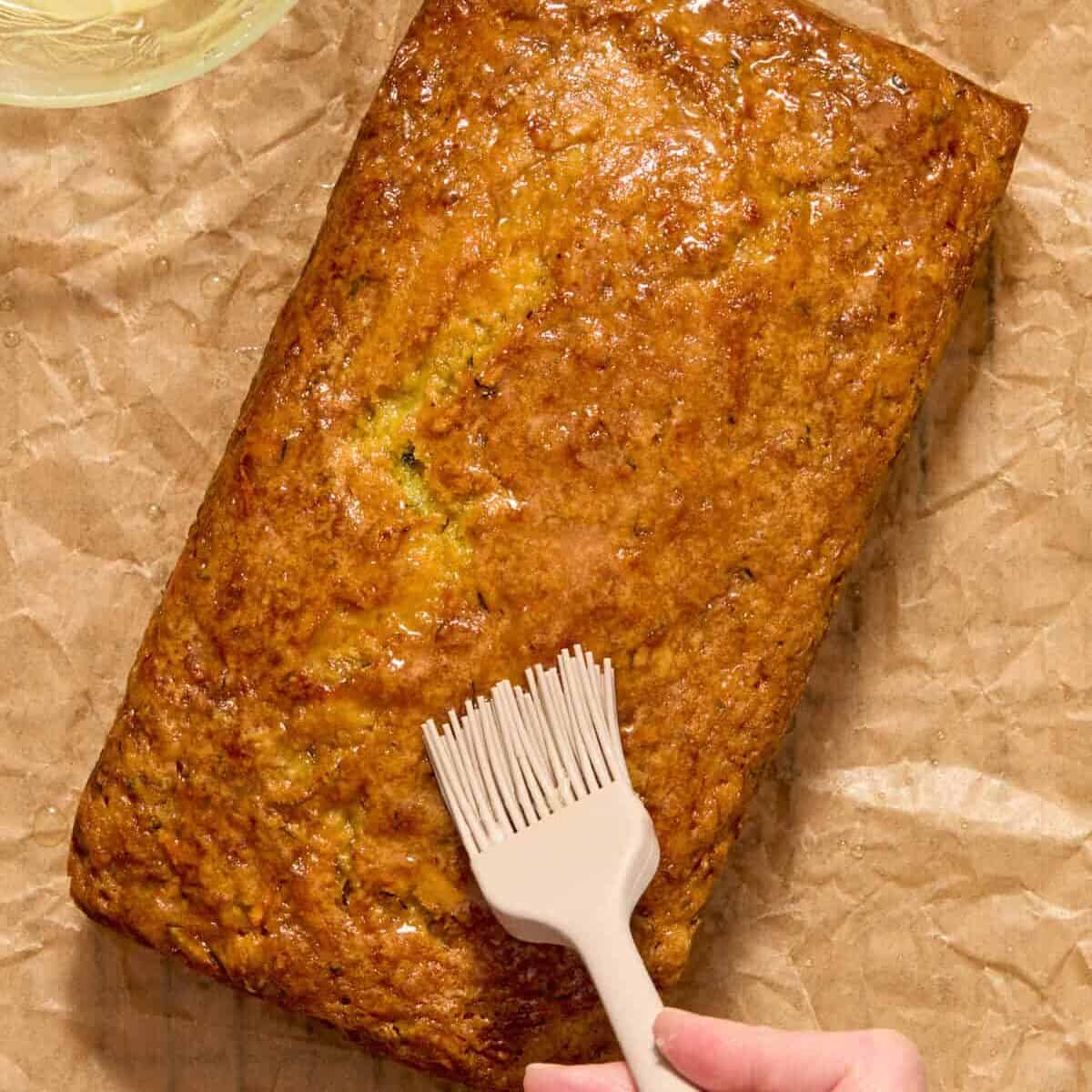 Lemon glaze brushed on top of baked loaf with pastry brush.