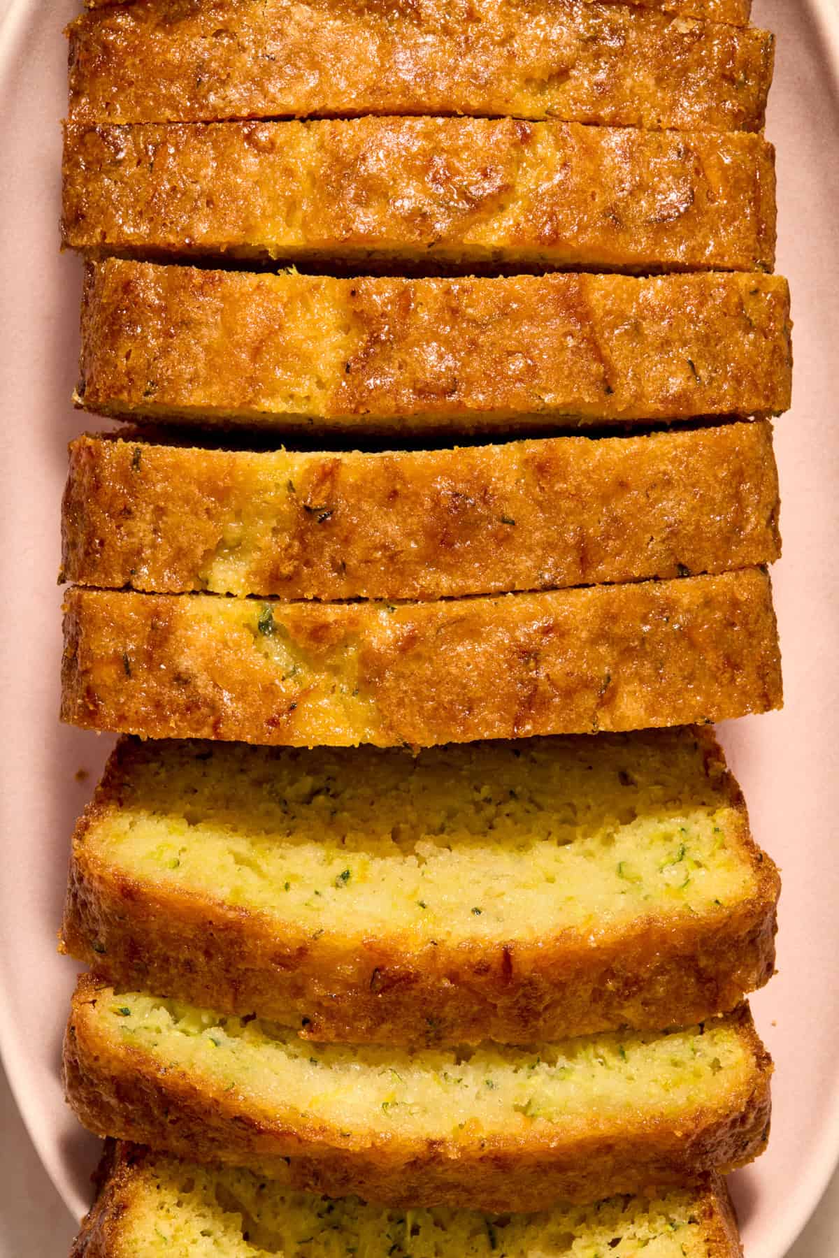 Slices of lemon glazed loaf of lemon zucchini bread.