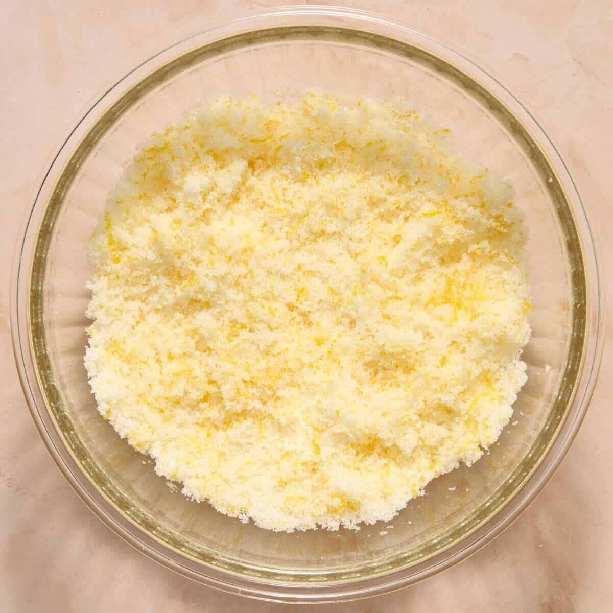 Lemon and sugar massaged together in glass mixing bowl.