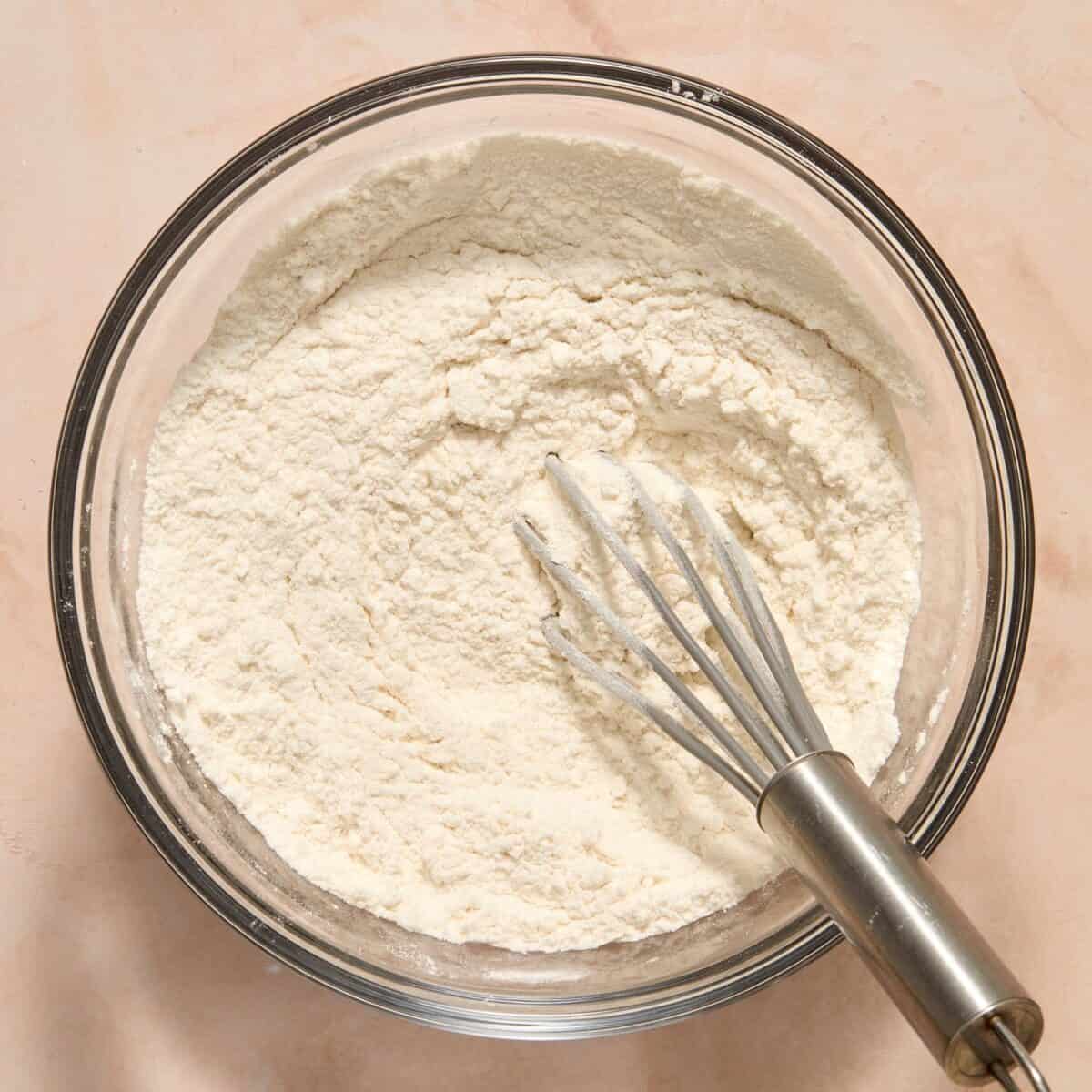Whisked dry ingredients in bowl with small whisk.
