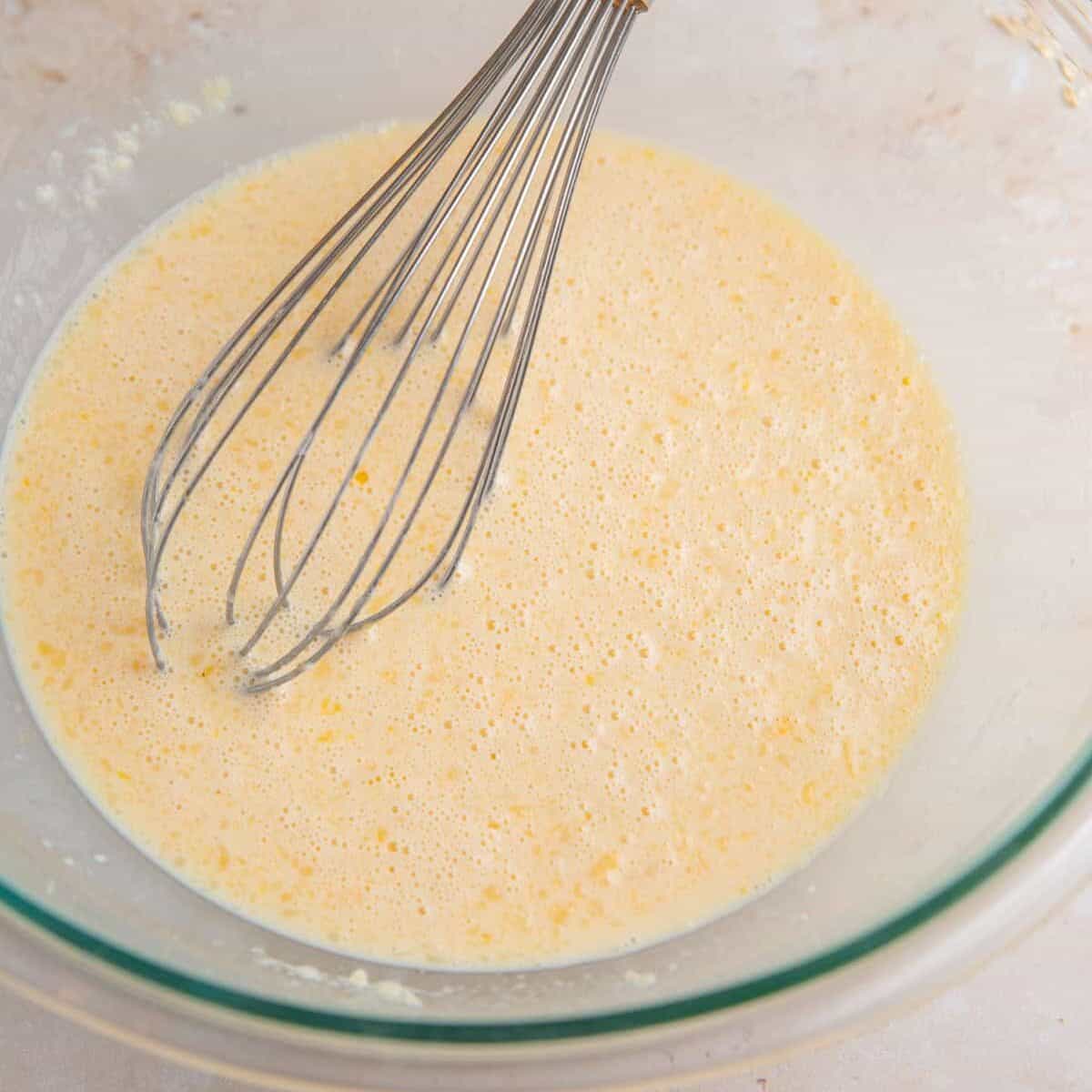 Wet ingredients mixed in bowl with whisk.