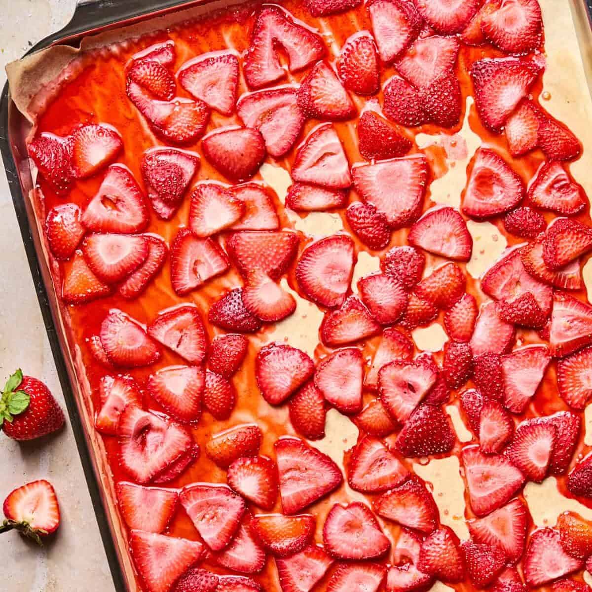 Roasted strawberries on parchment lined baking pan.