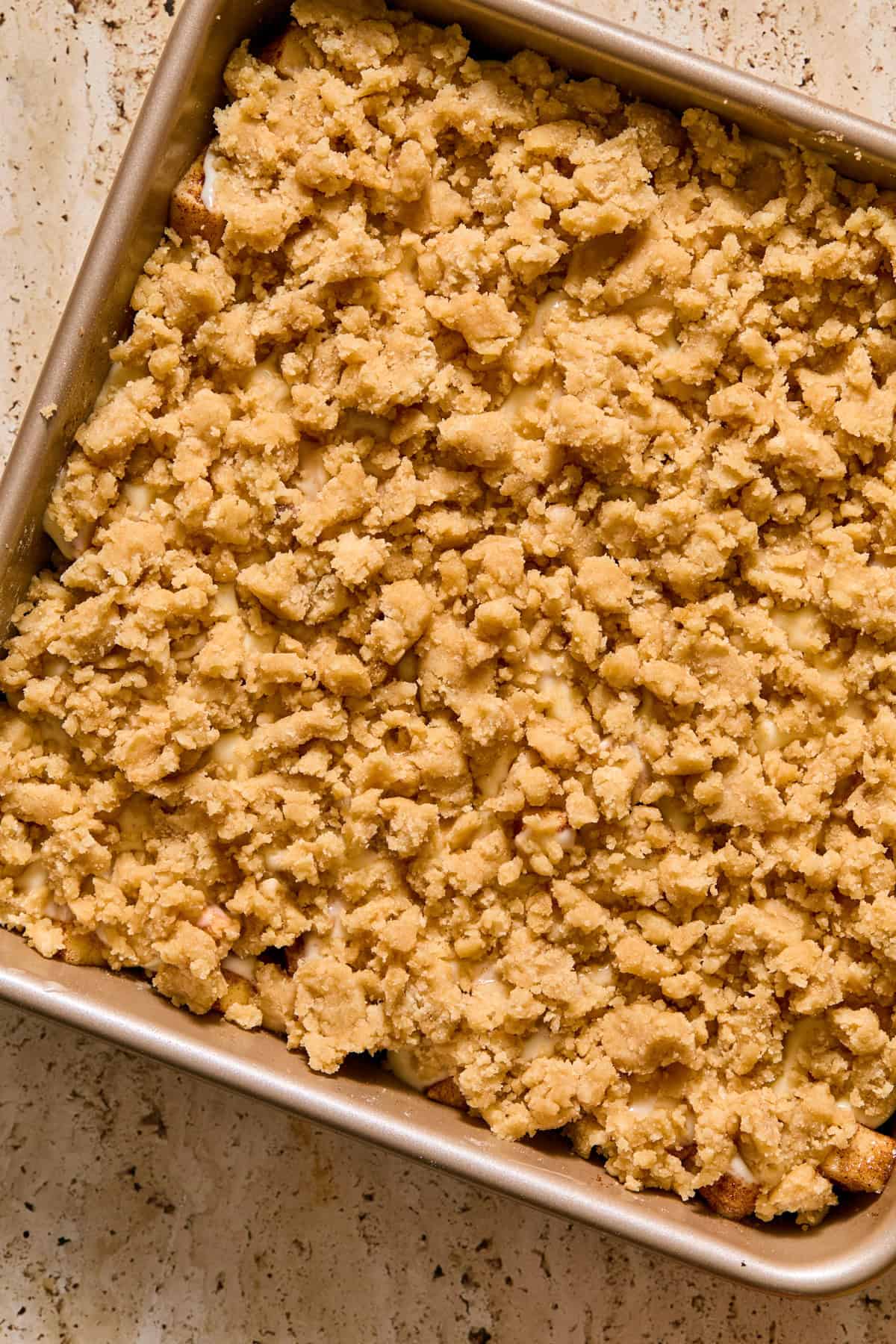 Cobbler mixture sprinkled over apples and cream cheese.