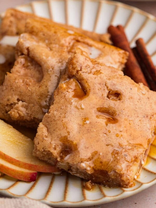 Stack of apple cinnamon sheet pan protein pancakes topped with maple syrup.