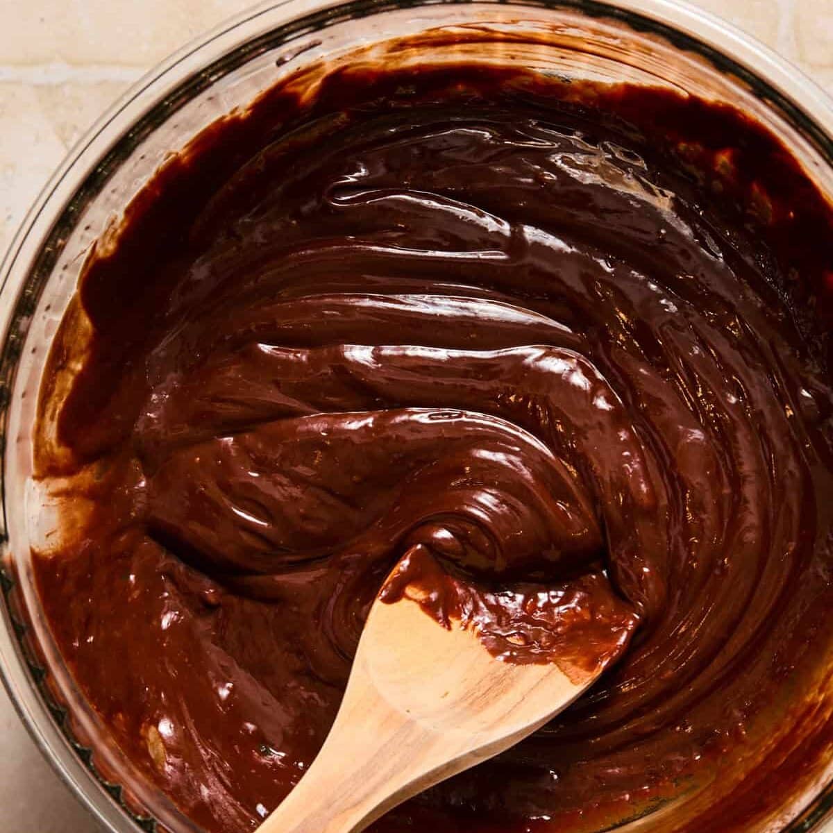 Melted chocolate and heavy cream ganache in bowl.