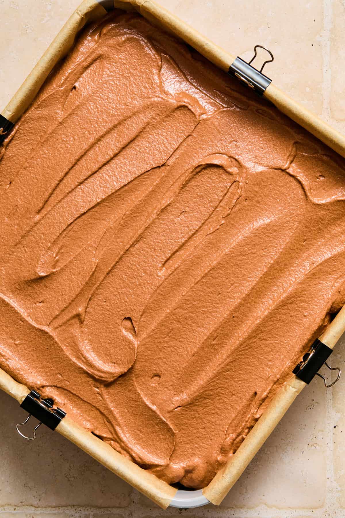 Chocolate ganache and whipped cream filling spread evenly over Oreo crust in pan.