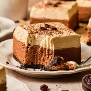 Layered espresso martini no bake bar on plate with forkful taken out.