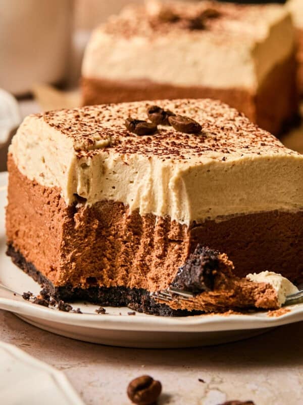 Layered espresso martini no bake bar on plate with forkful taken out.