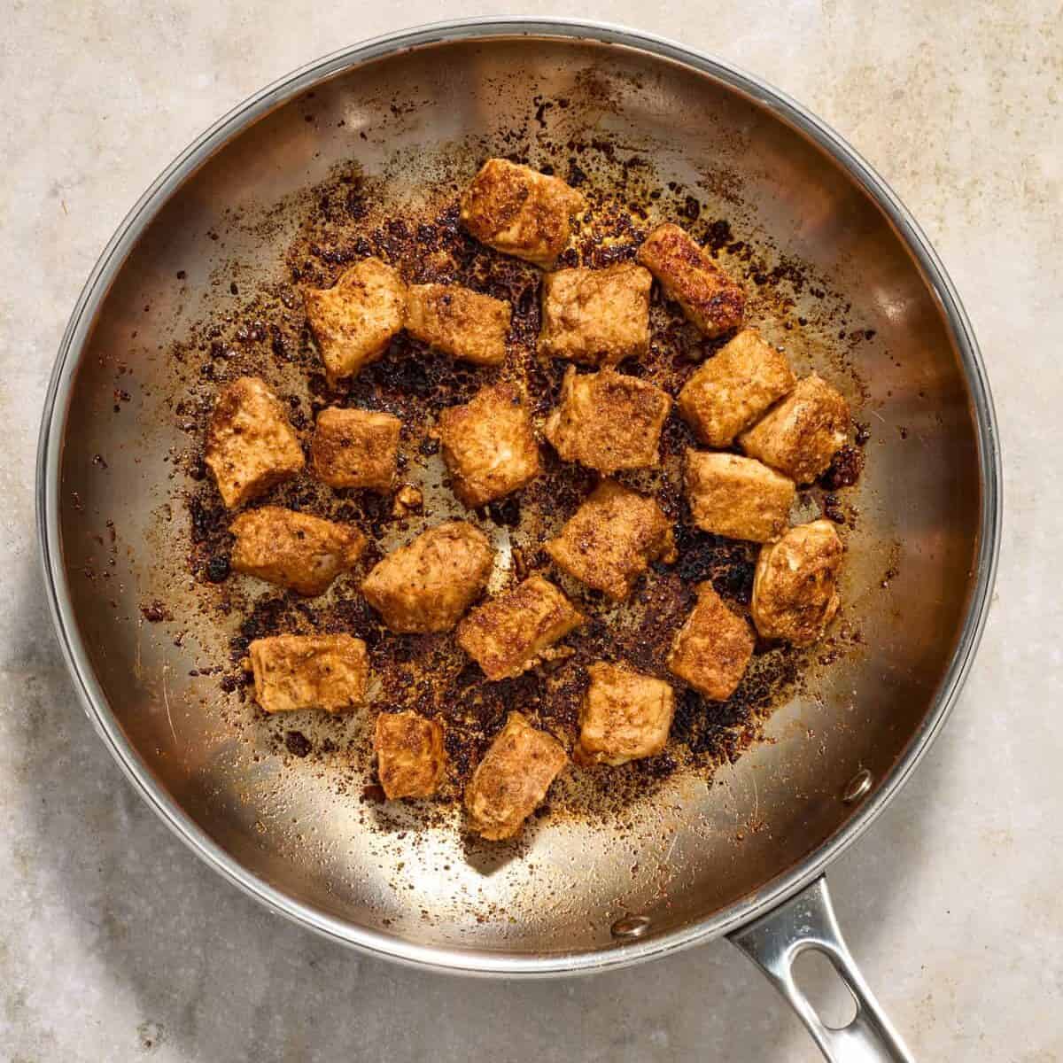 Skillet with cooked fish bites for tacos.