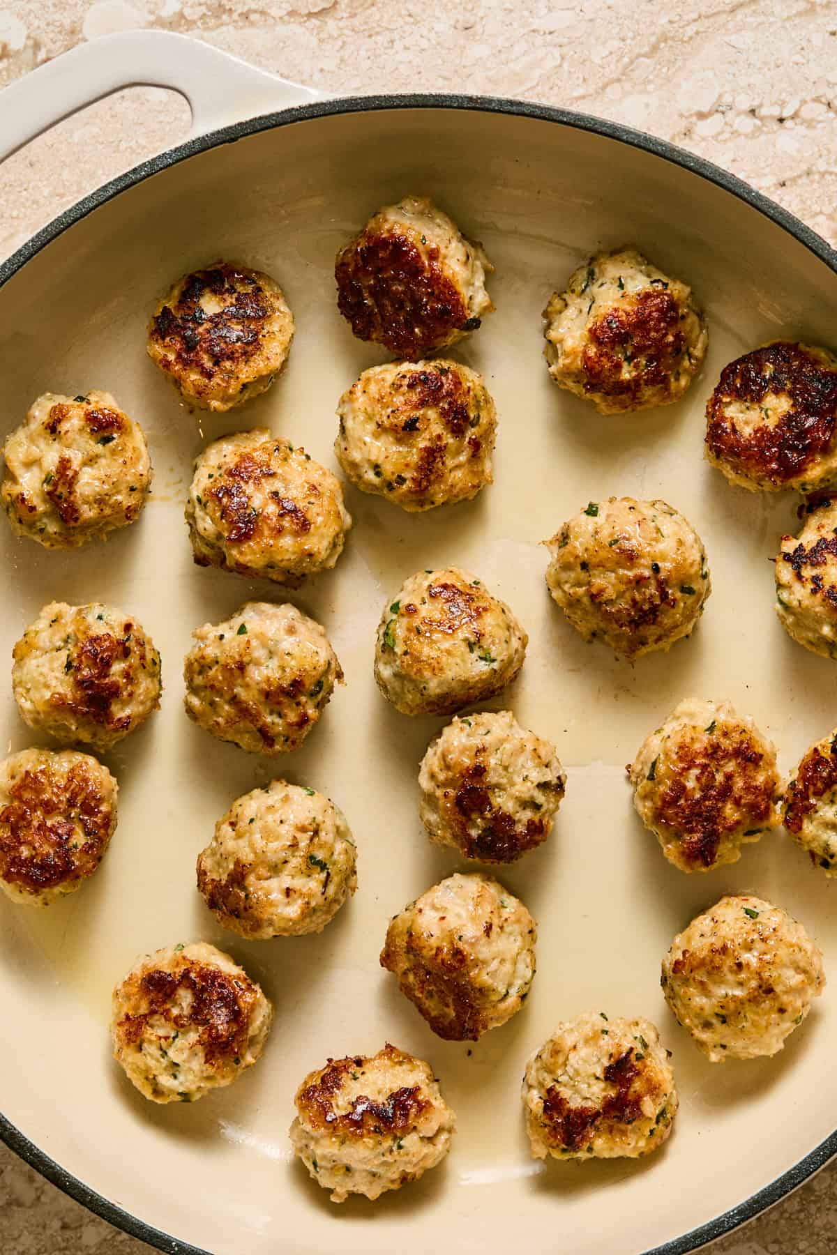 Seared meatballs in skillet.