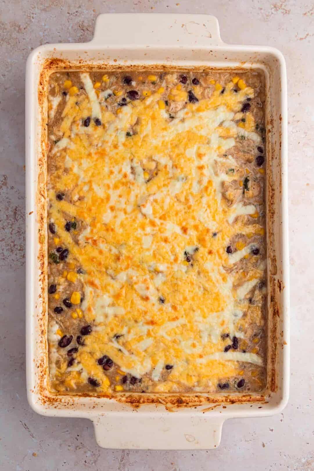 Baked salsa verde chicken and rice with cheese on top.