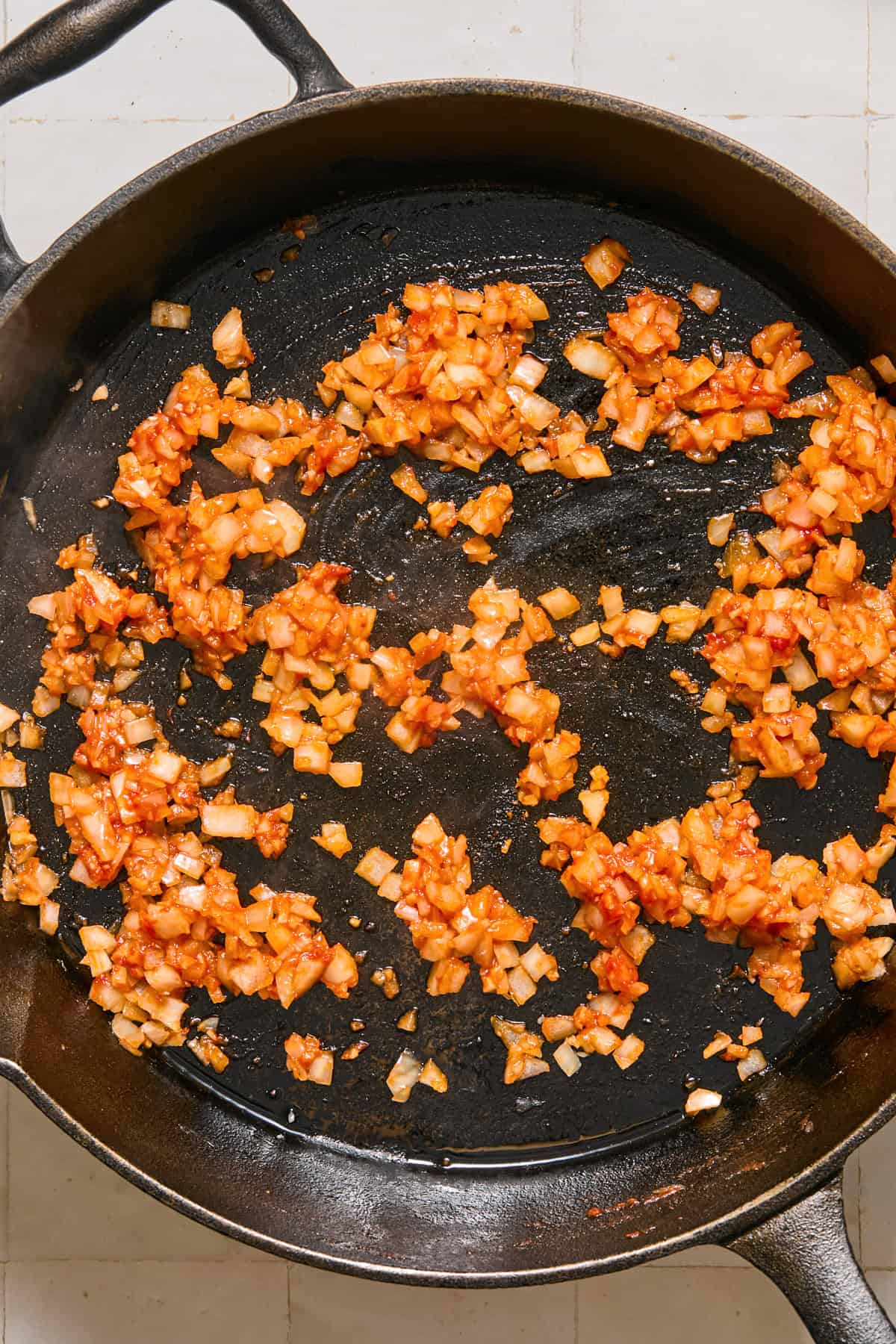 Onions, garlic and tomato paste in cast iron skillet.
