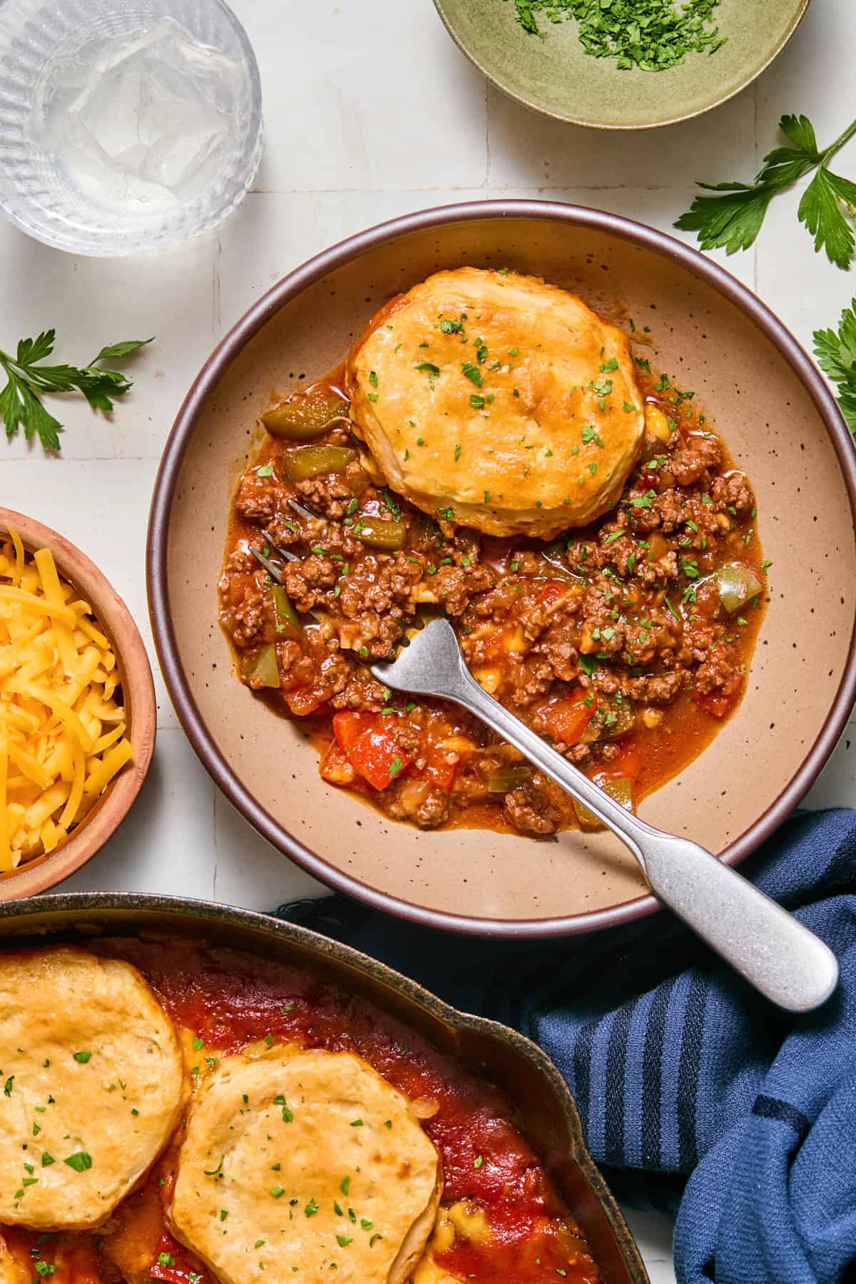 Dish with biscuit topped sloppy Joe mixture with fork.