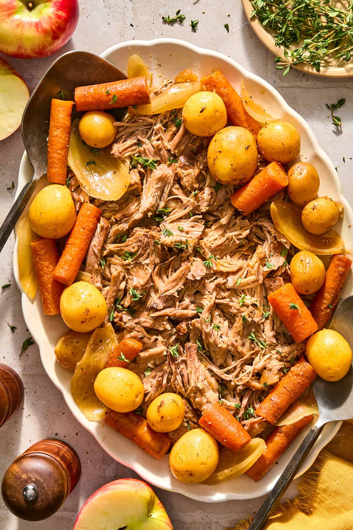 Apple cider pork roast served on plate with potatoes, onions and carrots.