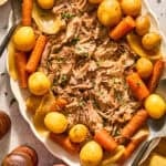 Plate with pork roast on and carrots and potatoes.