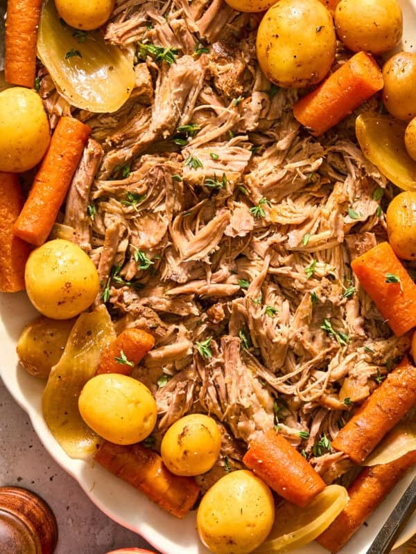 Plate with pork roast on and carrots and potatoes.