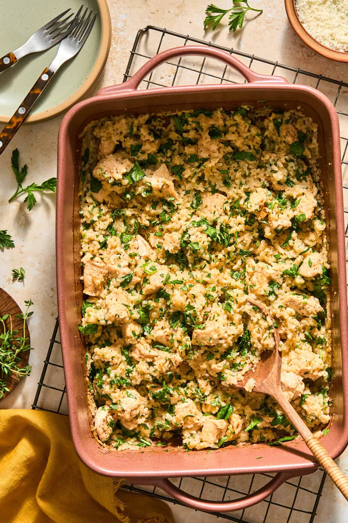 Butter herb chicken and rice bake in pan with serving spoon.