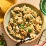 Butter herb chicken and rice served in bowl with fork.