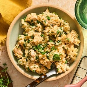 Butter herb chicken and rice served in bowl with fork.