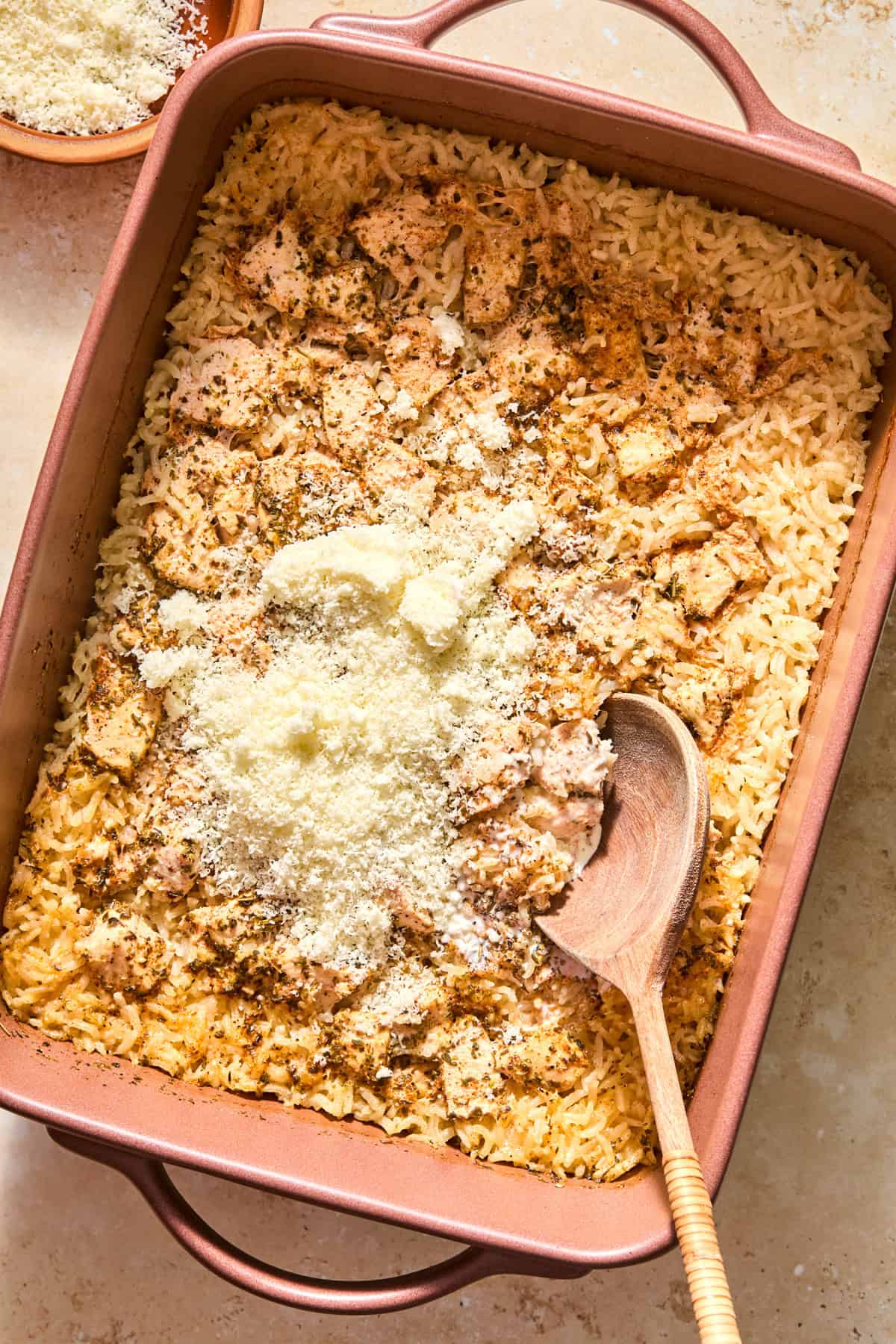 Parmesan added to baked chicken and rice casserole.
