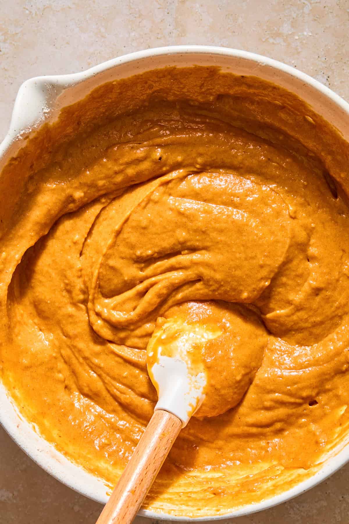 Pumpkin bread batter in bowl with spatula.