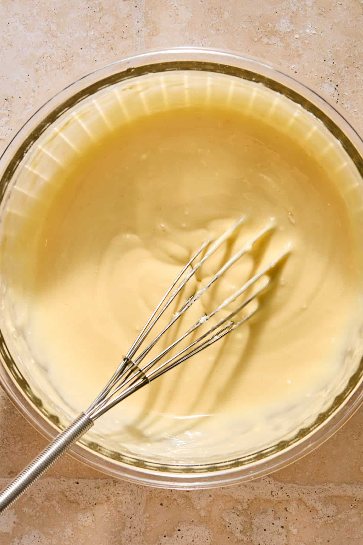 Cream cheese mixture in bowl with whisk.