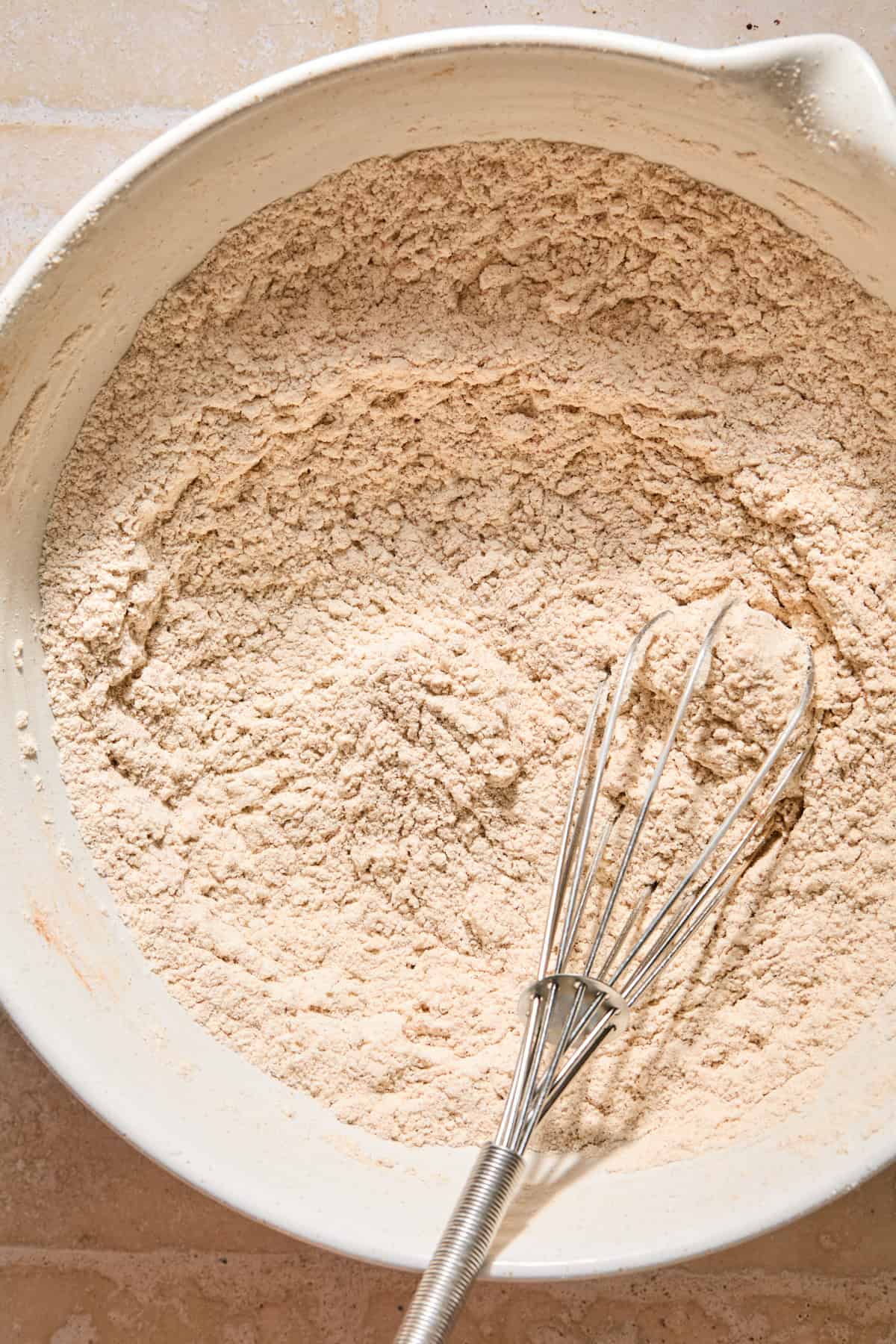 Dry ingredients in bowl with whisk.