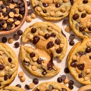 Peanut butter chocolate chip cookies with peanut butter centers on surface.