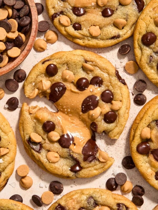 Peanut butter chocolate chip cookies with peanut butter centers on surface.