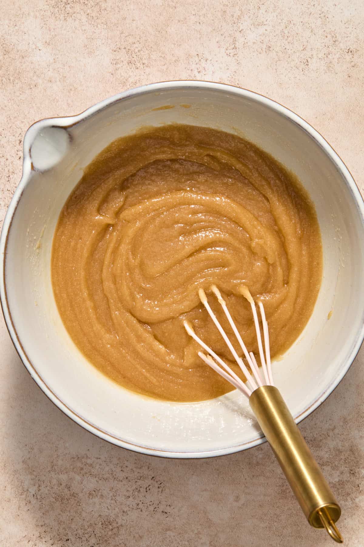Sugars and butter mixed in bowl with whisk.