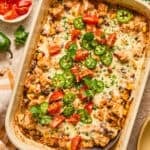 Baking pan with chicken taco and rice bake topped with cilantro and tomatoes.