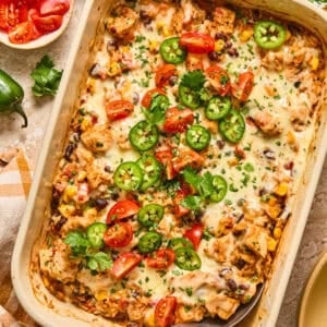 Baking pan with chicken taco and rice bake topped with cilantro and tomatoes.
