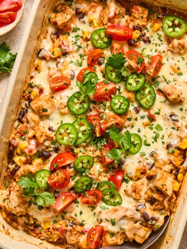Baking pan with chicken taco and rice bake topped with cilantro and tomatoes.