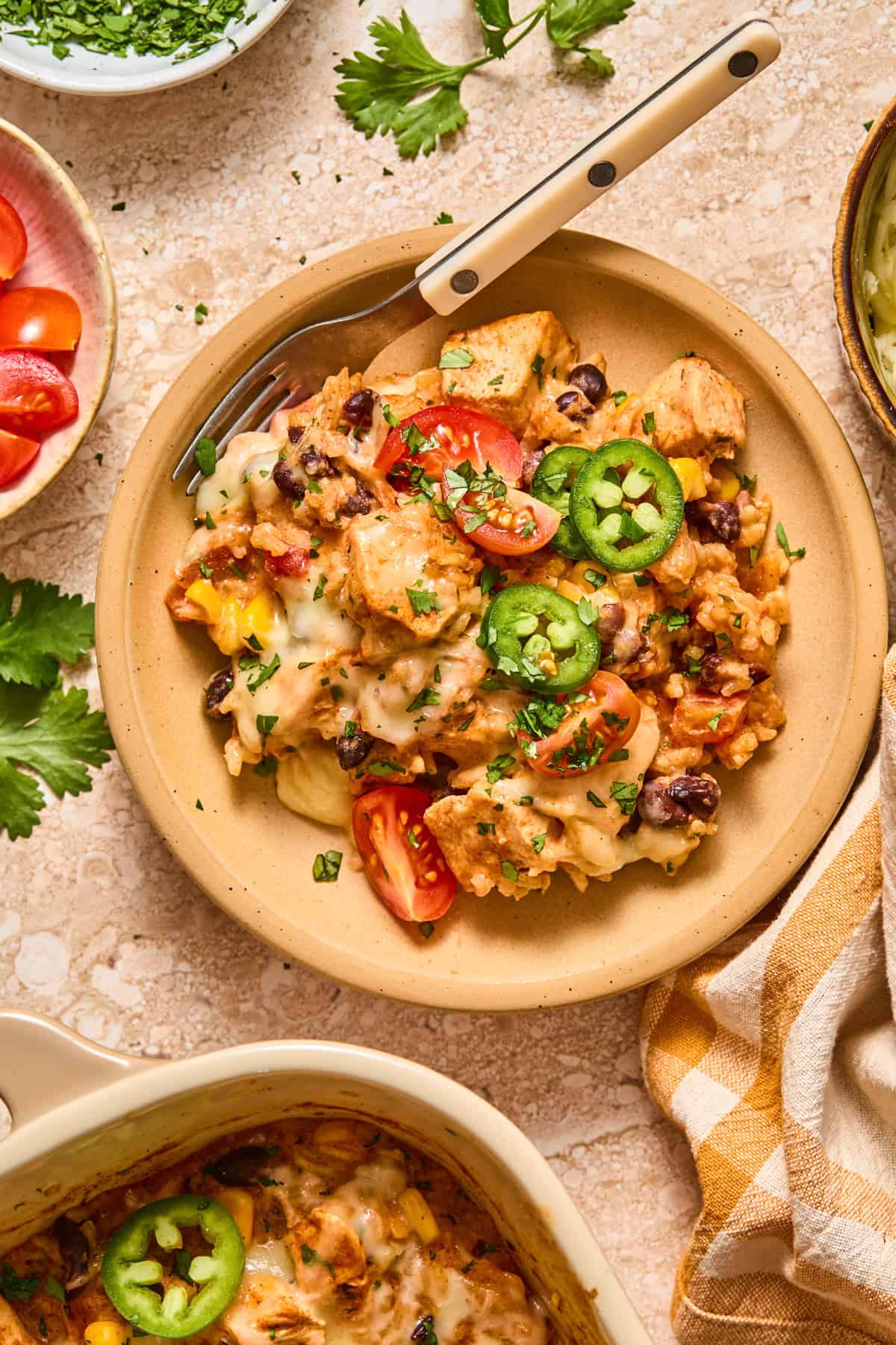 Bowl with serving of chicken and rice with jalapeños and tomatoes on top.
