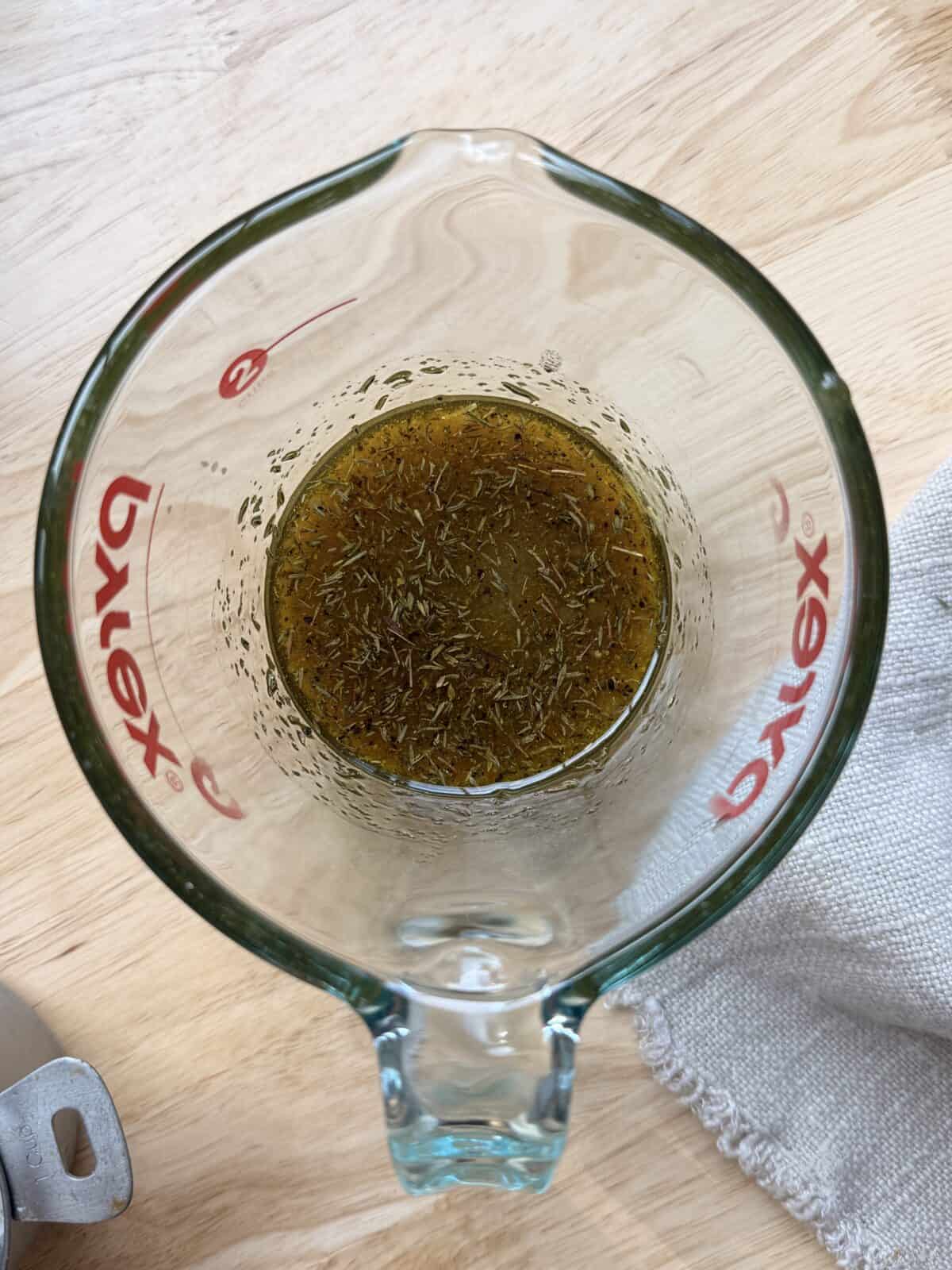 Maple dijon mixture in glass measuring cup.