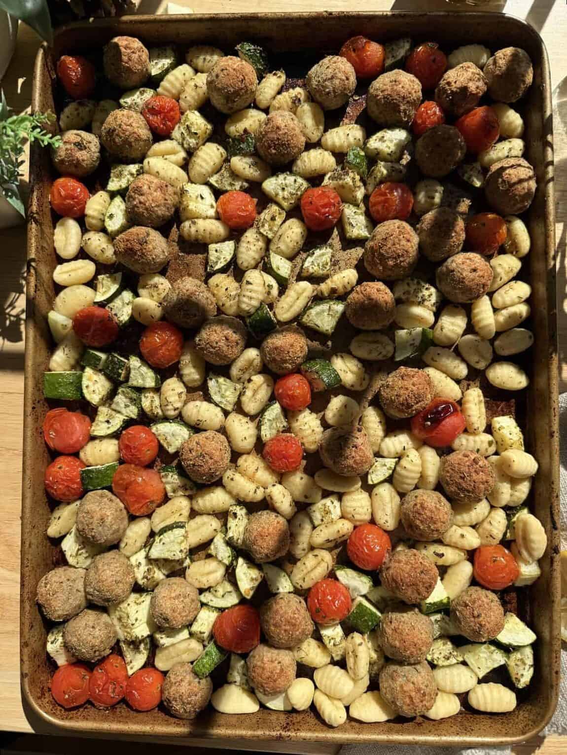 Baked sheet pan gnocchi and meatballs with vegetables.