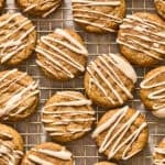 Maple and dark brown sugar cookies with icing drizzle on wire rack.