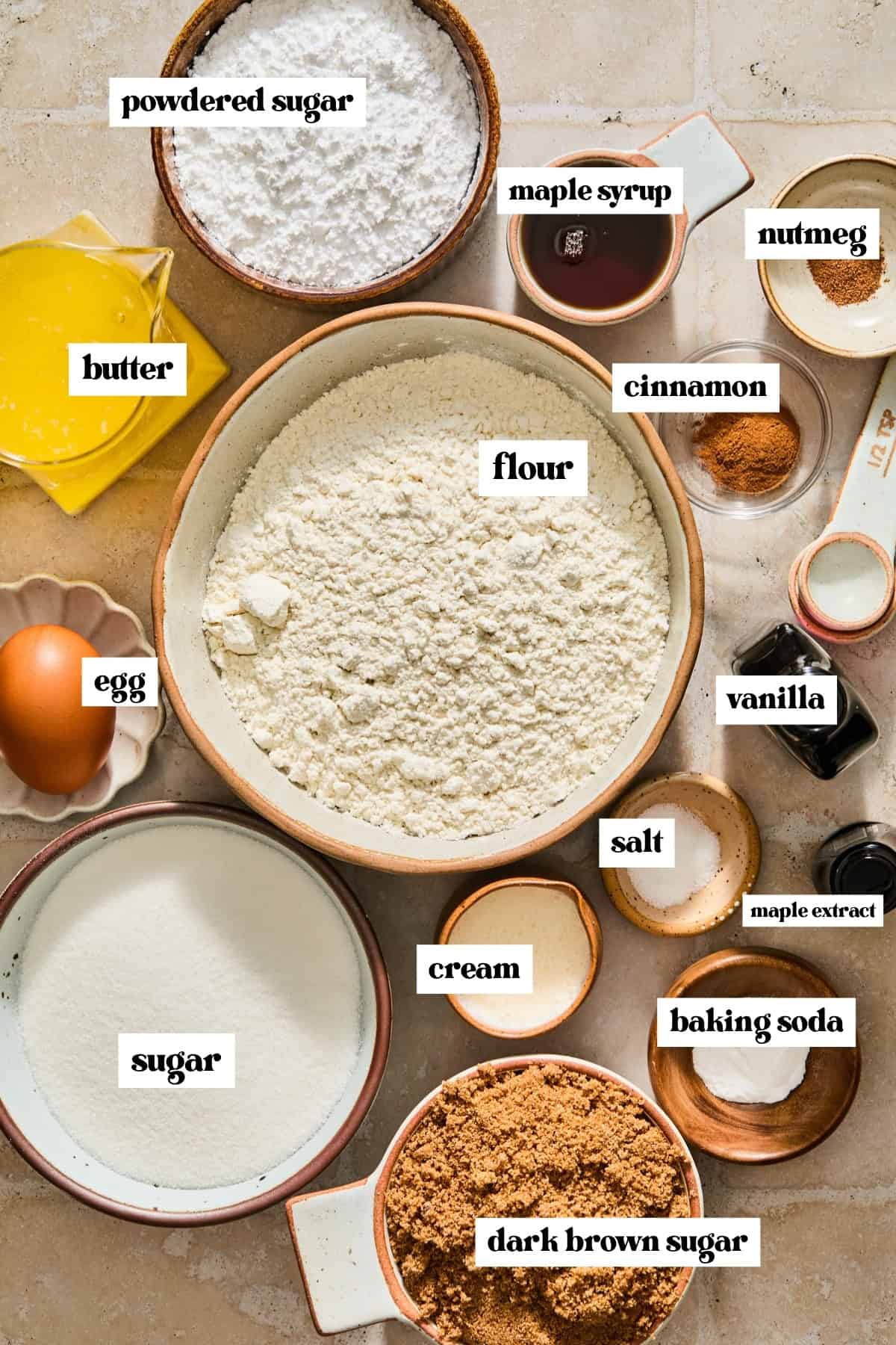 Flour, sugar, butter, egg and other labeled ingredients on surface.