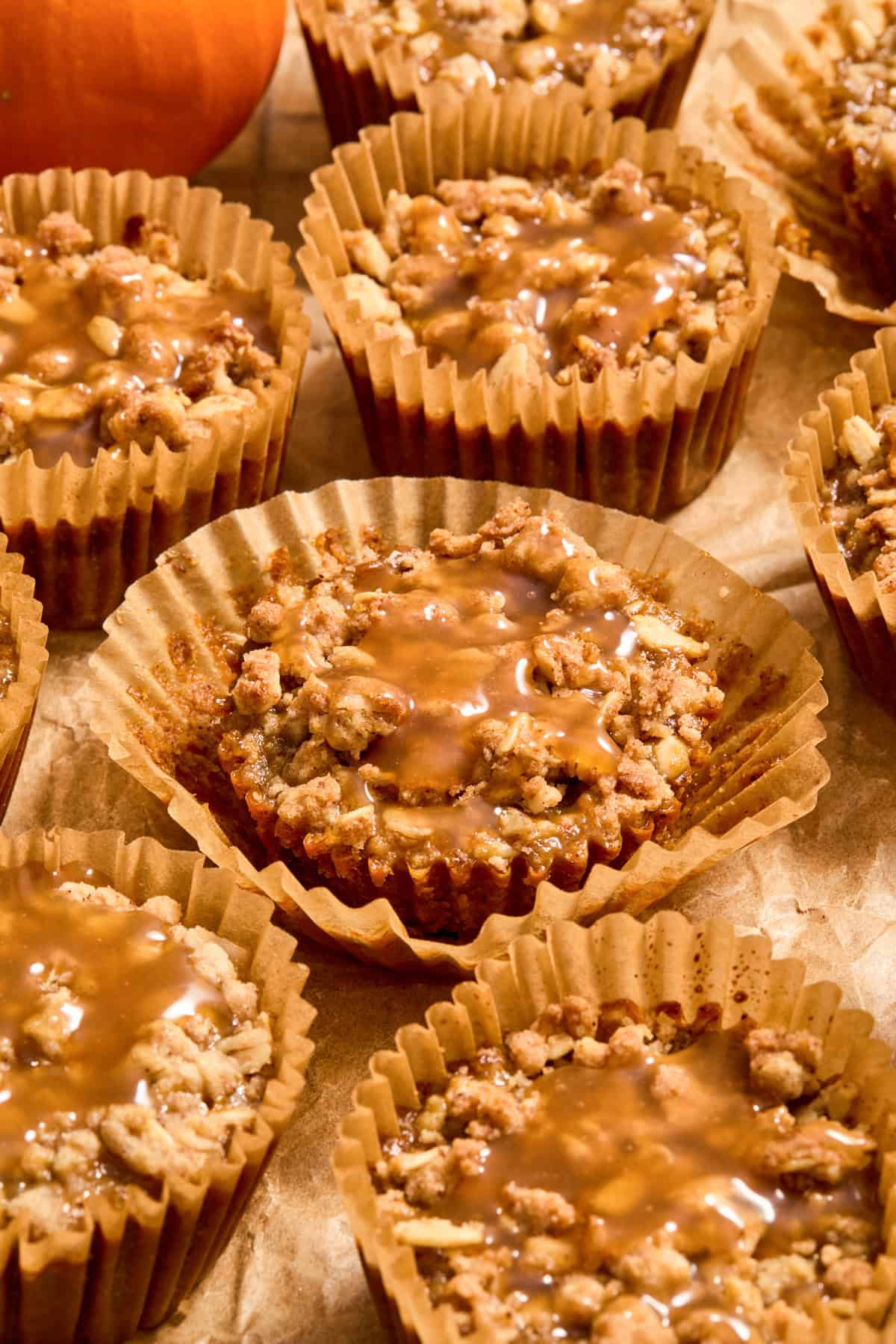 Mini pumpkin crisps in muffin liners with caramel drizzle over top.