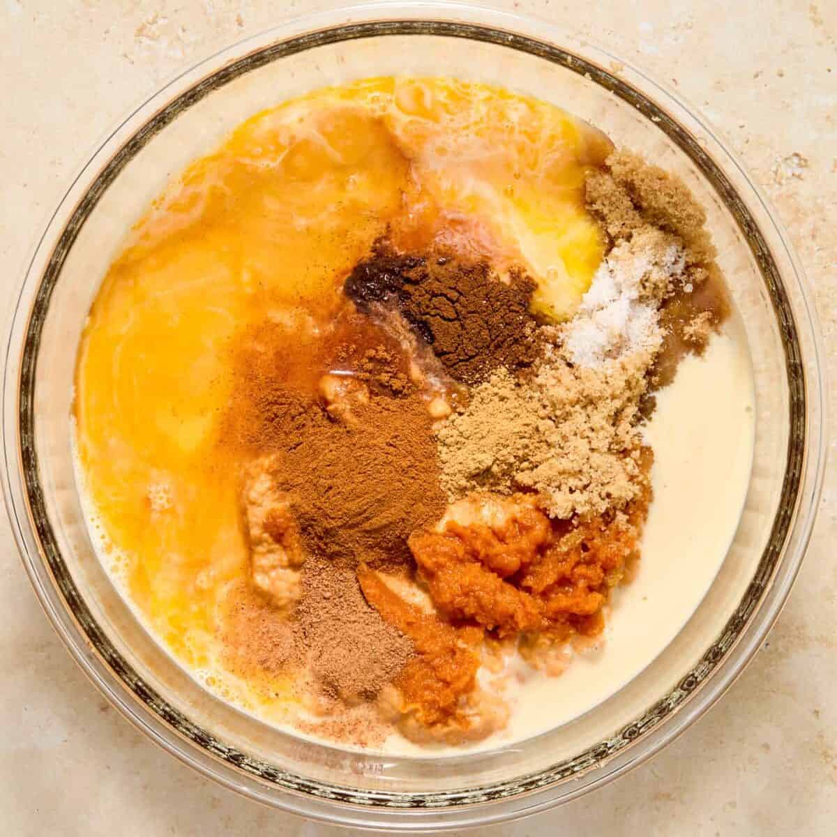Pumpkin, brown sugar, warm spices, evaporated milk and other ingredients in bowl.