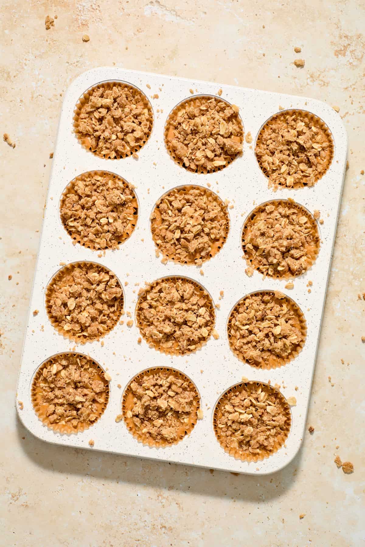Individual pumpkin crisps in muffin liners in pan before baking.