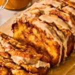 Pumpkin spice loaf on parchment with icing glaze.