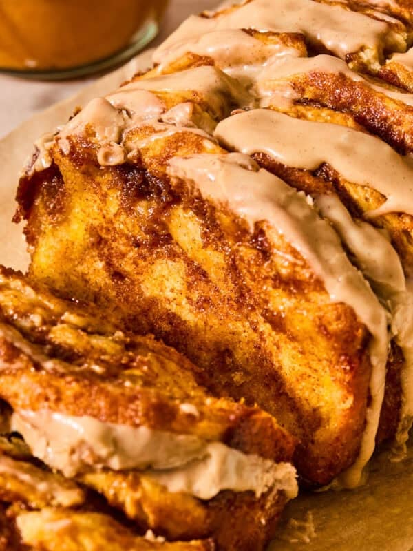 Pumpkin spice loaf on parchment with icing glaze.